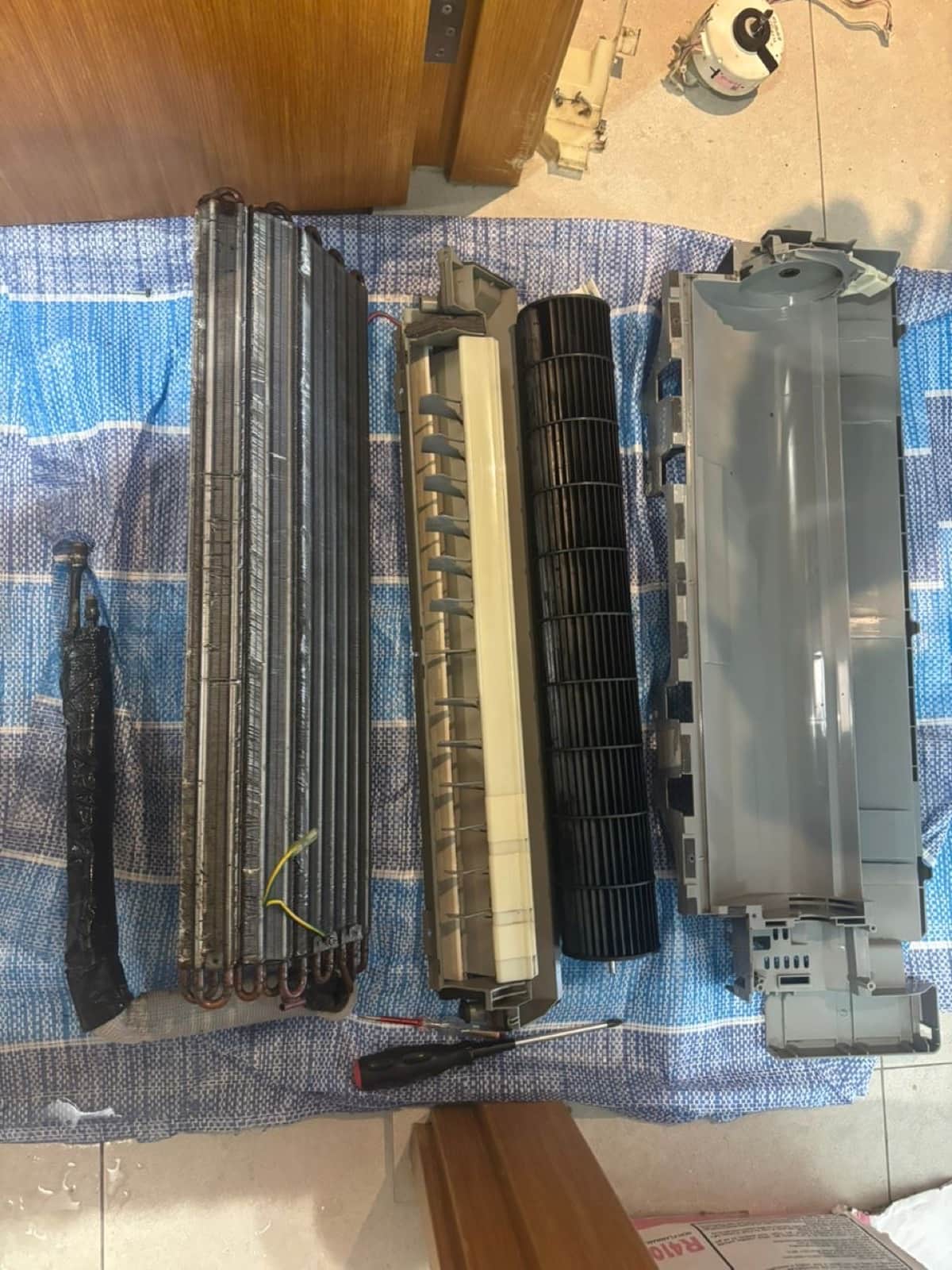 Fan coil unit fully dismantled on a floor sheet for a chemical overhaul
